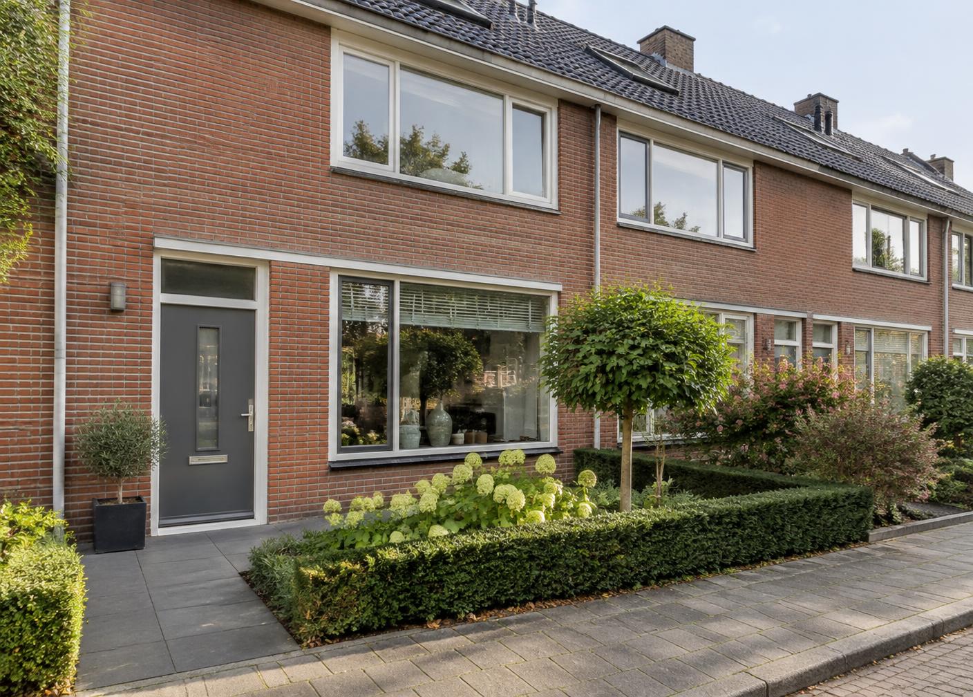 Moderne Nederlandse woning met grote ramen aan een rustige straat